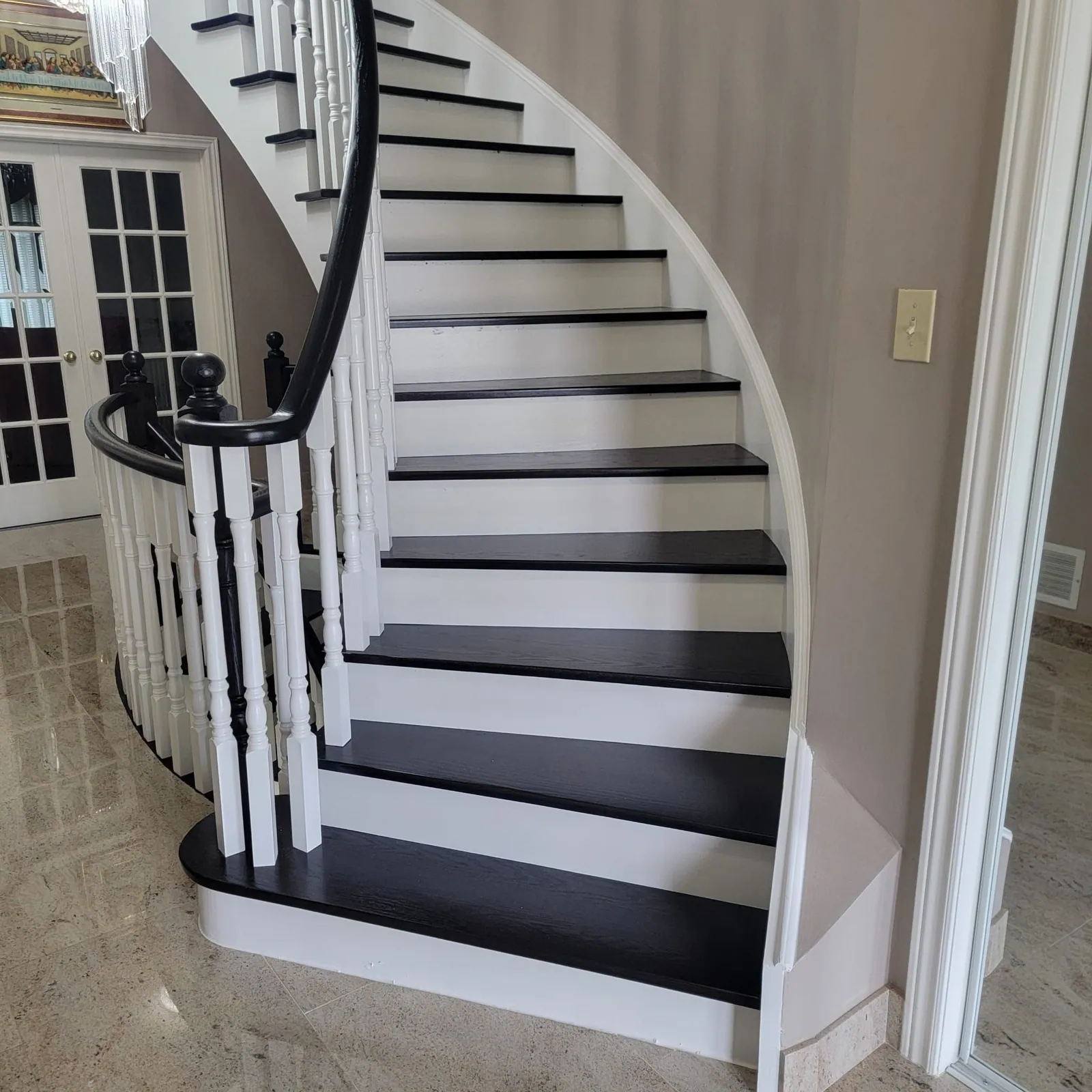 Curved staircase with dark treads and white risers.